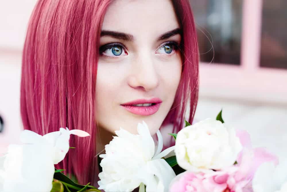 An attractive,, young woman with straight, pink hair.