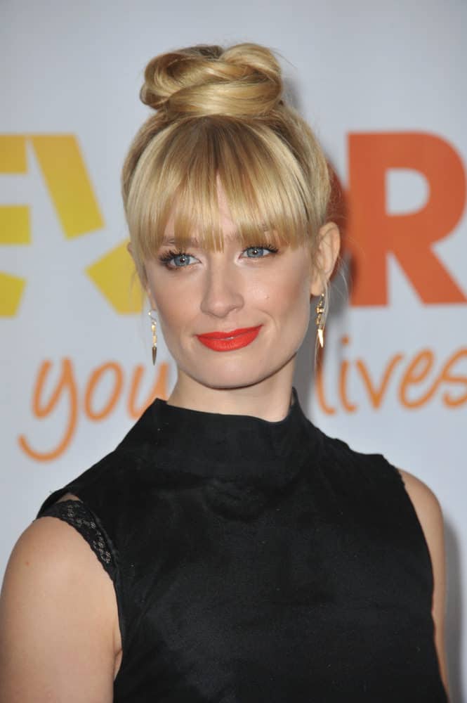 Bangs and buns can go together, especially if you’ve got eye-grazing fringe like Beth Behrs. The trick is to keep the style sleek. Straighten the hair and pull it up into a very high ponytail. Wrap the ends around into a neat but soft bun.