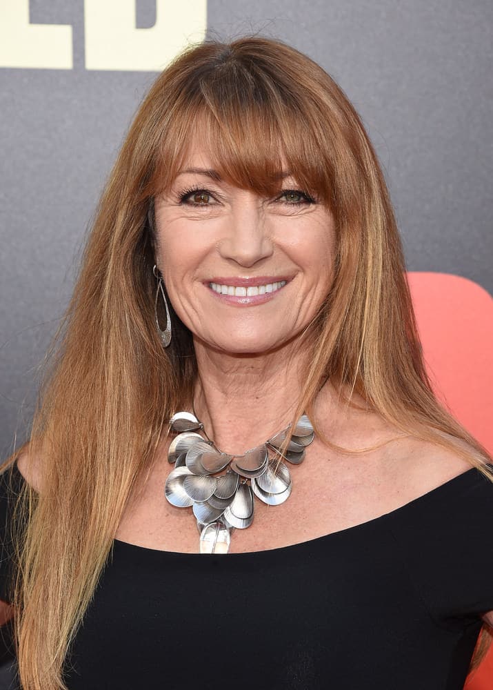 In this style, modeled by celebrity Jane Seymour, long, chestnut-colored hair strands are layered and rest gently on the shoulders of the wearer. The color of the hairstyle shifts from chestnut at the top, to a honey blonde color at the tips of hair strands, resembling a reverse ombre effect. In addition to these colored long layers, side-swept and tapered-cut bangs are included in the hairstyle as a unique supplement.