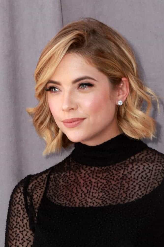 Ashley Benson was at the Comedy Central Roast of Justin Bieber at the Sony Pictures Studios on March 14, 2015, in Culver City, CA. She was lovely in a stunning all-black outfit with her chin-length curly sandy blonde hairstyle with long side-swept bangs.