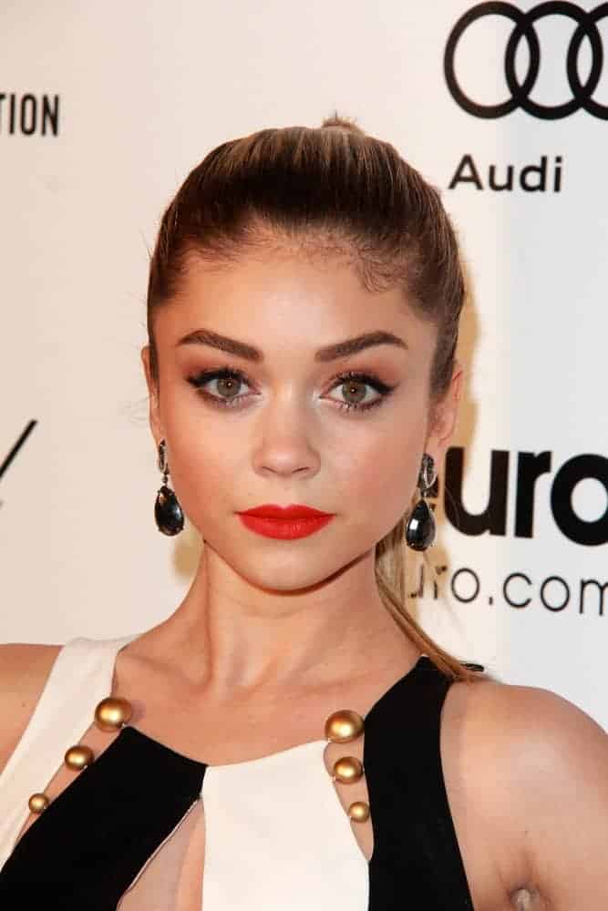 Sarah Hyland attended the Elton John Oscar Party 2015 at the City Of West Hollywood Park on February 22, 2015, in West Hollywood, CA. She paired her stunning dress with red lipstick and a slicked-back high ponytail hairstyle.