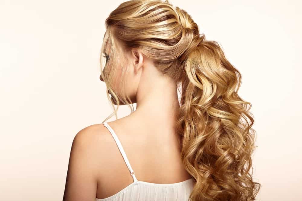 Low ponytails are back in fashion — and why shouldn’t they be, given they can be styled in so many ways. This style features lots of waves and curls in the loose part of the ponytail. The style starts as a braid at the crown of the head but then flows down into a ponytail.