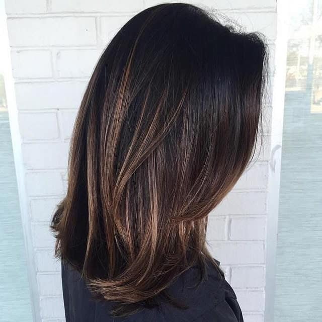 Brown balayage on black hair is one of the coolest and most natural hair looks. The coffee brown highlights on this woman’s black hair gives a very flattering effect.