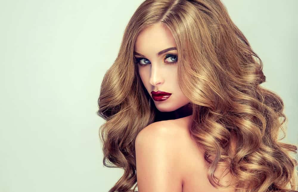 Thick, bouncy curls may be the most appealing type of hairstyle on women. Add a great color, and you are guaranteed to turn heads. This young woman is rocking a metallic toffee brown color with bright golden undertones. This look is great for people with thick, lustrous hair.