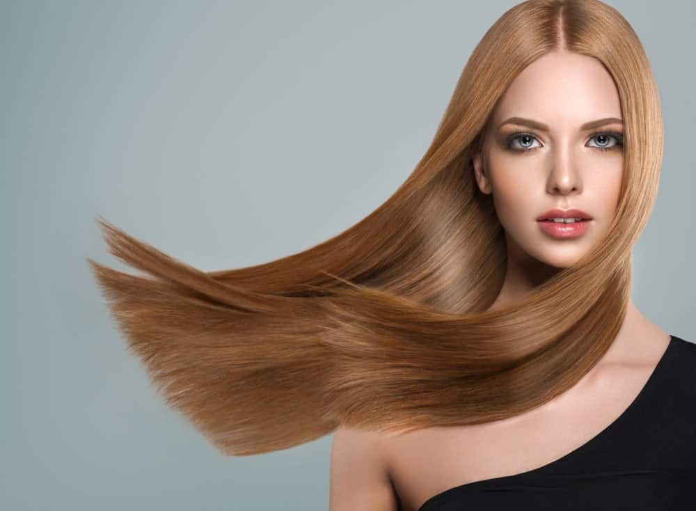 Straight and sleek hair highlights the health of your locks to the maximum. Take a look at this model with beautiful ginger-brown hair. You can mimic the look by parting your hair in the middle and letting it fall down, straight. For the full effect, make sure your ends are cut bluntly. You can get straight, smooth and shiny hair with a nice keratin treatment.
