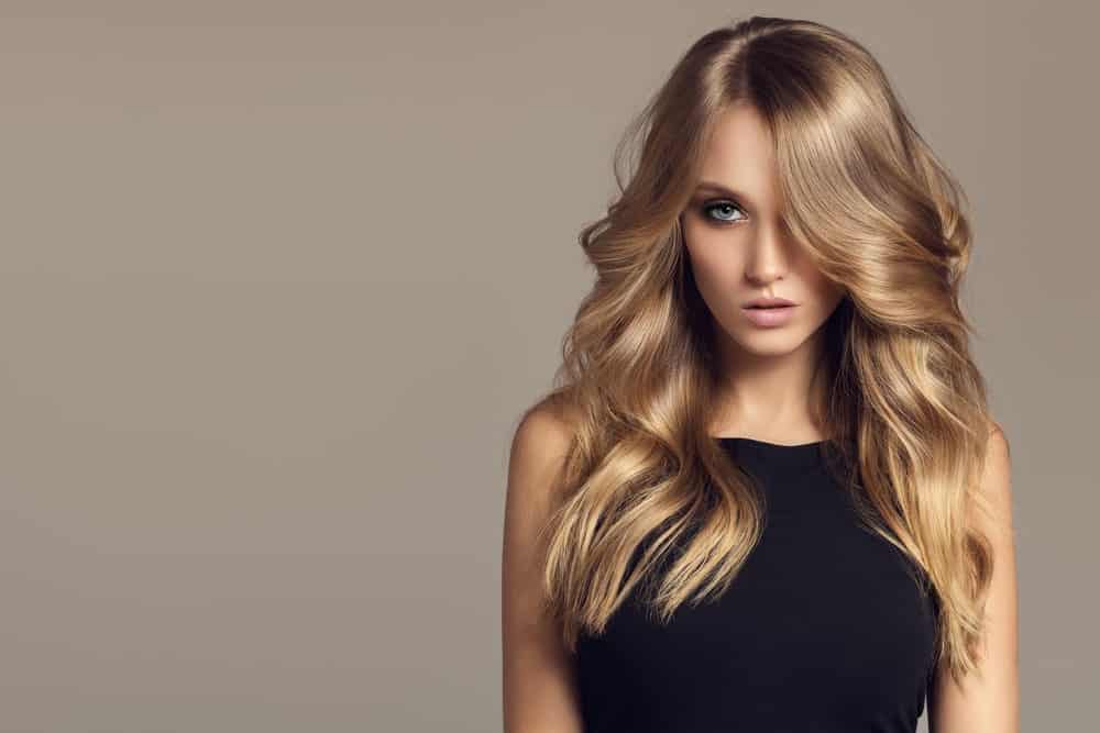 The great thing about light brown hair is that you can go as light as you want to blondish shades. This model displays how. Although her roots remain dark, the rest of her hair is given a very light brown-blonde hair color. Her long flowing locks are blow-dried into soft, subtle curls. The look seems effortless and breezy. What is so great about this hairstyle is that you can wear it to the office, a business meeting, a party, to the bar and even to a wedding, you name it.