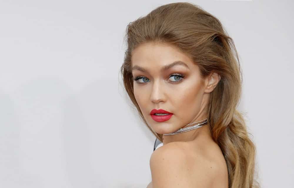 A lot of people are afraid of teasing their hair and for good reasons. However, if you are Gigi Hadid, this is the perfect way to do it. The supermodel has combed back her hair with some subtle backcombing and gave her gold-highlighted waves some loose curls. The light brown pushed-back hair enhances her pretty face shape and cheekbones. If you want to try the look without risking hair breakage, add weaves or hair fibers and invest in a hair thickening serum.