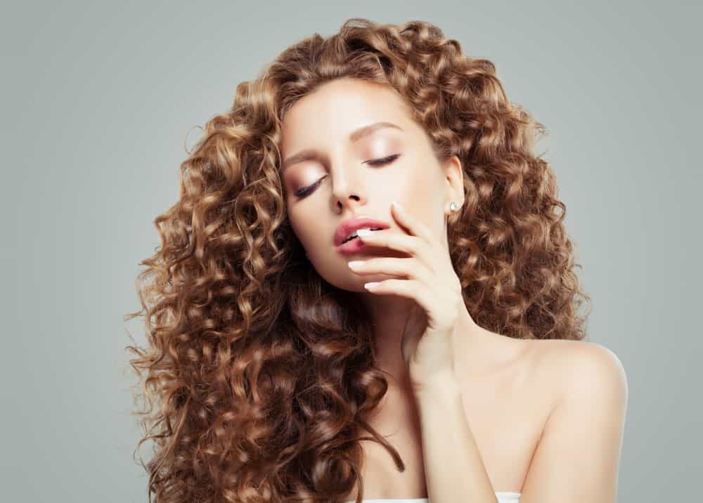 If your hair is this pretty, what else do you need to dress up for a party? This young woman rocks a solid chestnut-gold color in a riot of volumizing and springy corkscrew curls. You can get this look easily at home; add a bit of heat protectant to your hair, separate your locks into thin sections and then wrap them around a heated curling iron. Wait 10-15 seconds and then release them. You will soon have a heedful of playful, corkscrew curls.