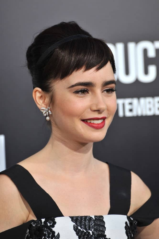 Use a hair accessory to create a voluminous look or pull your hair up into a chignon to achieve this faux short hairstyle – but rest assured you will look really stunning if you opt for uneven baby bangs like Lily Collins has done here. 