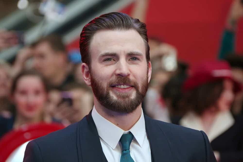 Who doesn’t love Captain America? Not only does he save the world, but he looks good doing it too. Chris Evans is known for his clean and polished look on the red carpet and this time isn’t any different either. The “Avengers” actor chose to style his thick hair in a side-parted slicked back part. With his beautifully groomed beard, the actor looks very refined and dapper.