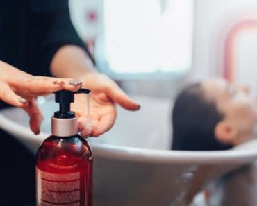 A Hairdresser WaA hairdresser washing customer’s hair with a hair shampooshes Customer’s Hair