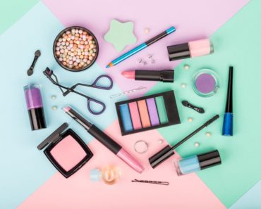 Several makeup products on a multicolored background