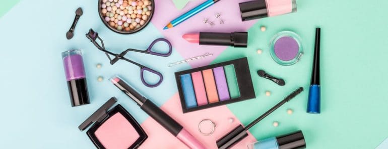Several makeup products on a multicolored background