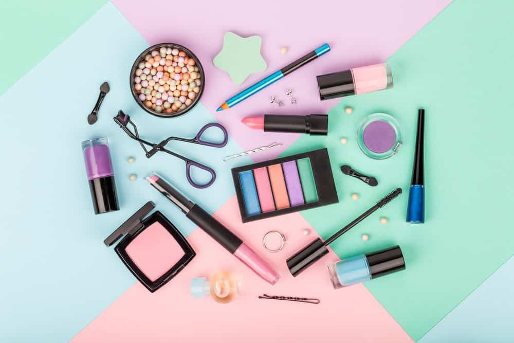Several makeup products on a multicolored background