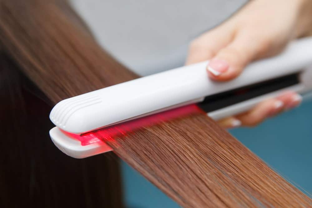 A woman getting heat treatment for her hair