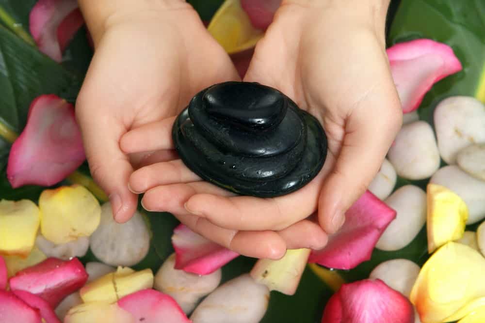 A woman holding a black stone 