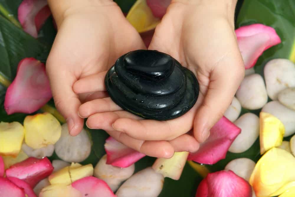 A woman holding a black stone