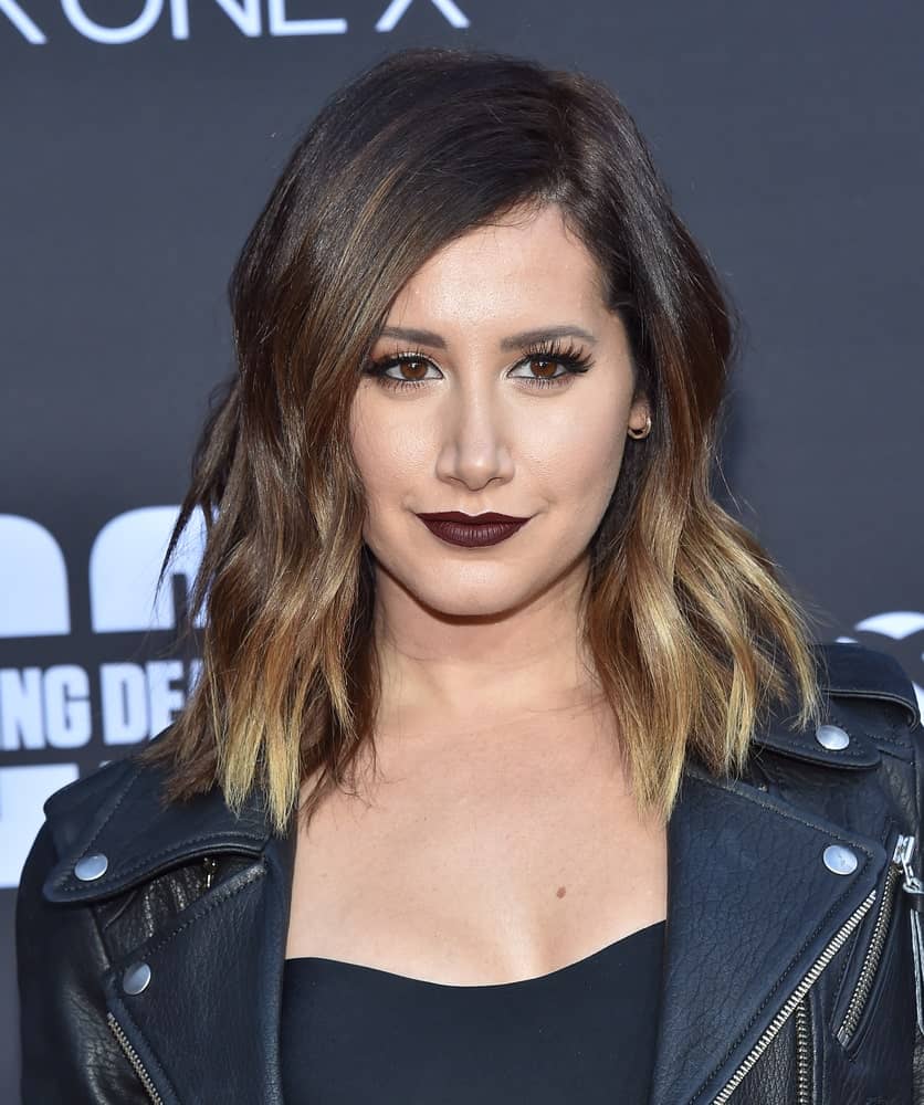 The actress rocks a highlighted beach wave perm on her outgrown hair during the 'The Walking Dead' Season 8 Premiere on October 22, 2017. It complements well with her dark lipstick and black getup.