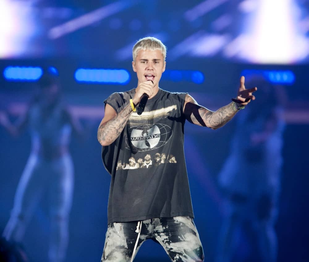 Justin Bieber performing in Pittsburgh on July 13, 2016, during the 'Purpose' world tour sporting a short hairstyle that's dyed in platinum blonde. It has dark highlights for some depths and dimensions.