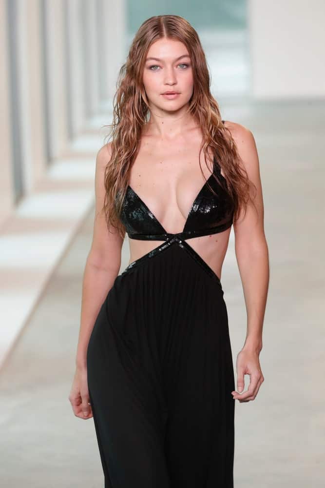 Gigi Hadid's hair was styled into a wet-look tousled and wavy loose hairstyle when she walked the runway wearing Michael Kors Spring 2019 on September 12, 2018 in New York City.