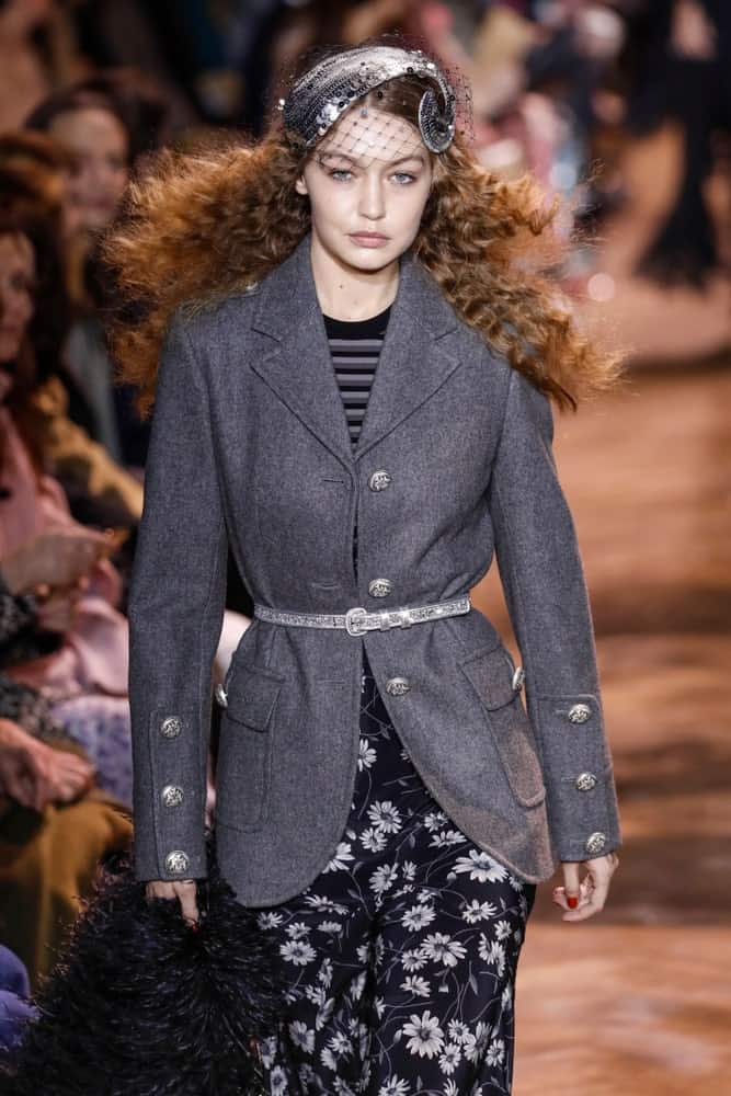 Gigi Hadid walked the runway at the Michael Kors fashion show during New York Fashion Week on February 13, 2019 in New York City. Hadid's Hair was styled with a curly loose finish and fitted with a quirky headdress.