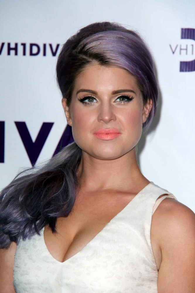 Kelly Osbourne on 16th of December 2012, sporting a long purple hair in a ponytail with bangs swept aside.