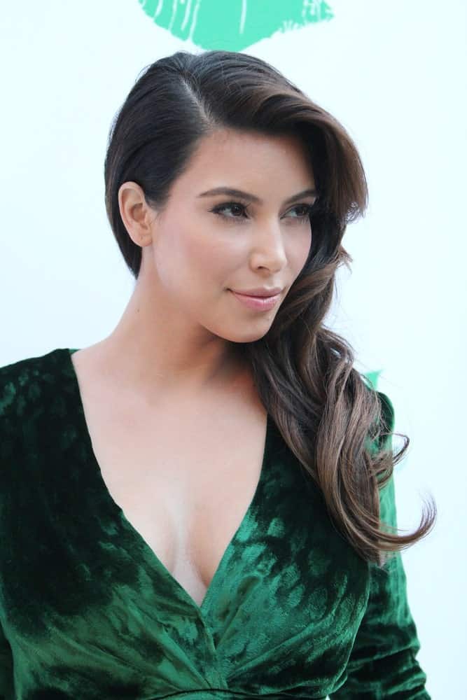 Kim Kardashian gathered her wavy locks on one side and styled it with a deep side part during the Midori Makeover Parlour at Fred Segal on September 25, 2012.