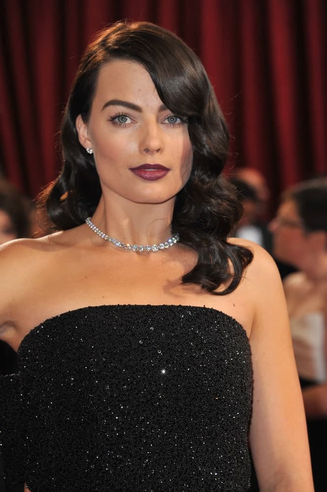 Margot Robbie exhibited a Hollywood glam look with her dark side-parted retro curls matching her sparkling black gown. This look was worn at the 86th Annual Academy Awards at the Dolby Theatre, Hollywood on March 2, 2014.