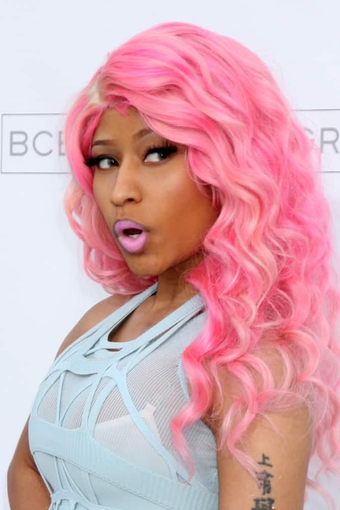 Nicki Minaj was in attendance at the 2011 Billboard Music Awards held at the MGM Grand Garden Arena in Las Vegas, NV. She wore a blue outfit to match her long and curly dyed pink hairstyle loose and tousled on her shoulders with a slight side-swept finish.