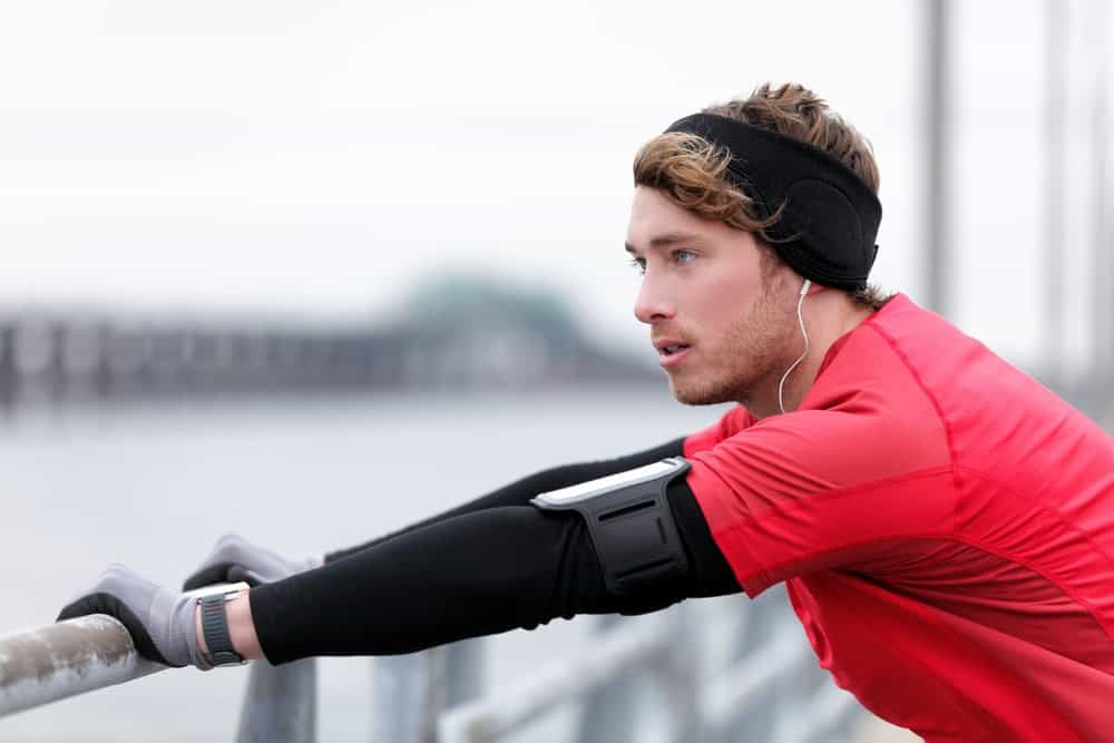 A man in the middle of a run wearing a winter headband.