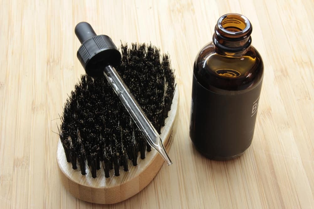 A bottle of beard oil, a dropper and a brush.