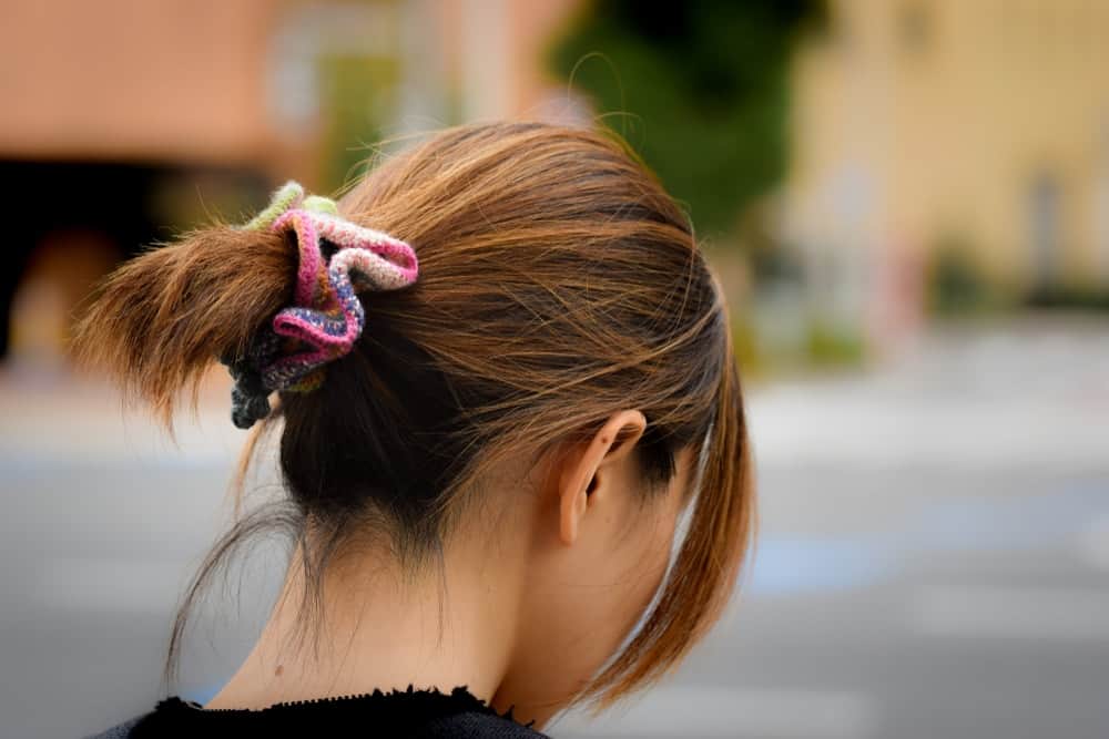 A woman wearing a colorful scrunchy.
